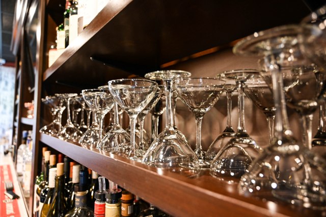 This is a photo of champagne glasses lined up and stored on a shelf in the bar area at the Federal.